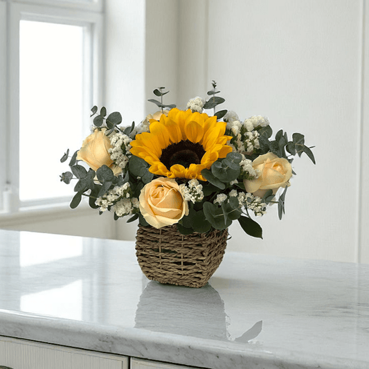 Close-up of Golden Shine flower arrangement featuring fresh sunflowers and peach roses in a small basket, perfect as a cheerful flower gift.