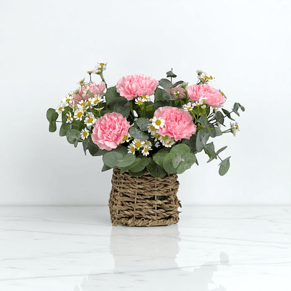 Close-up of Sweet Whisper basket with pink carnations and chamomile, ideal as a gentle and comforting flower gift.