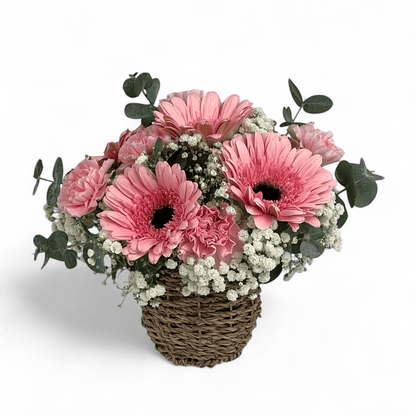 Close-up of Sugar Petals fresh flower arrangement with soft pink gerbera and carnations in a decorative basket.